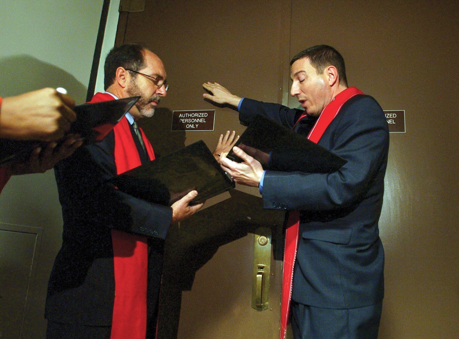 two pastors praying by an office door 